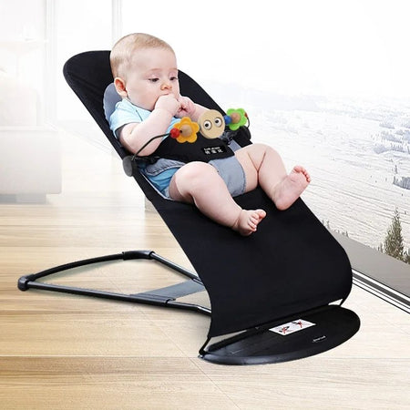 Un enfant assis dans le transat bébé noir incliné à 60°
