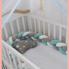Tresse de lit bébé blanc-gris-rose dans un berceau